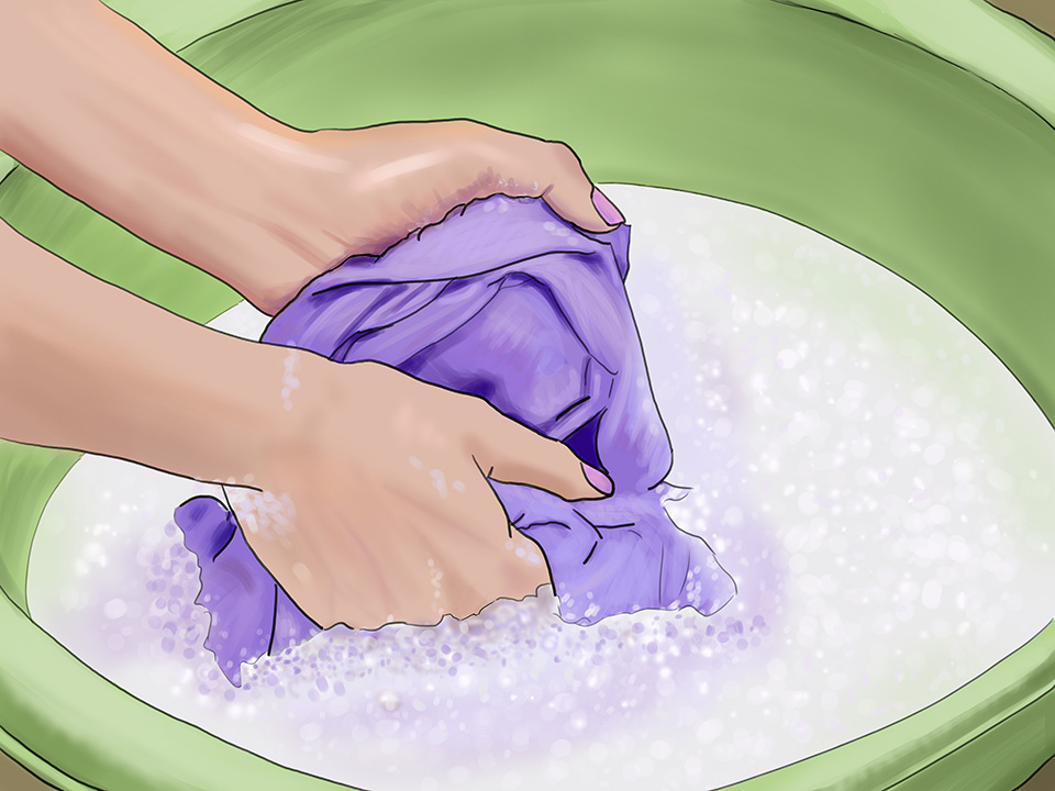 Hände waschen lilafarbene Wäsche in einem Zuber