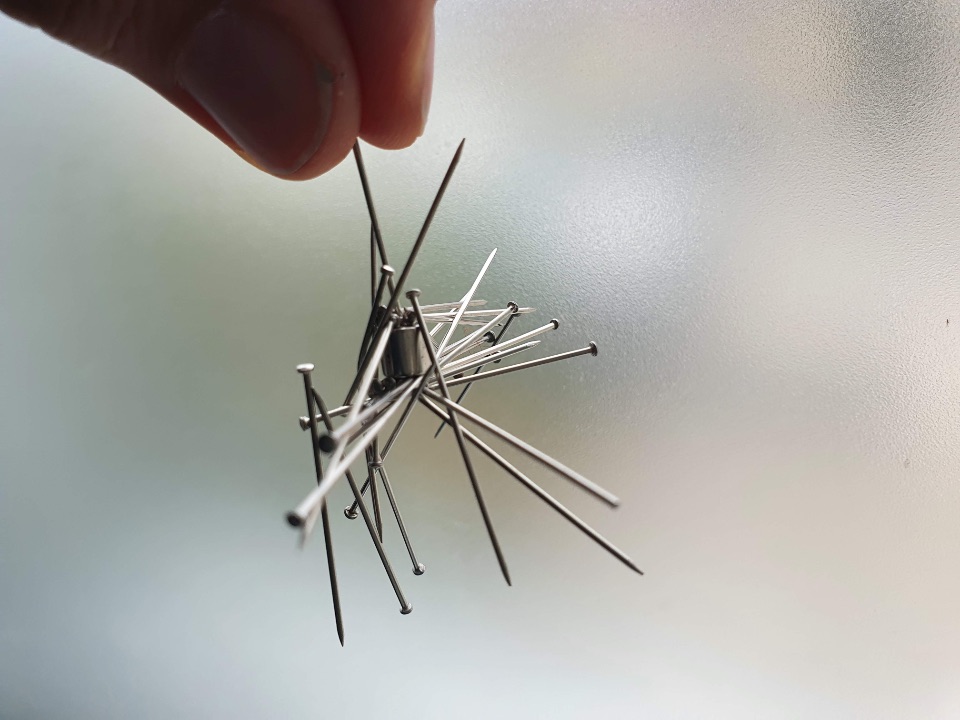 Viele Nadeln hängen an einem kleinen Magnetstück